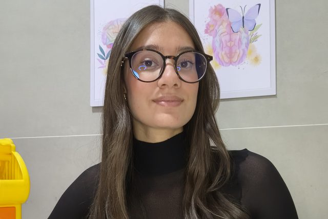 Nathalia com um jogo de encaixe de formas coloridas