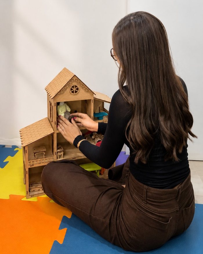 Nathalia Martinhão em sessão lúdica, montando uma casinha de brinquedo